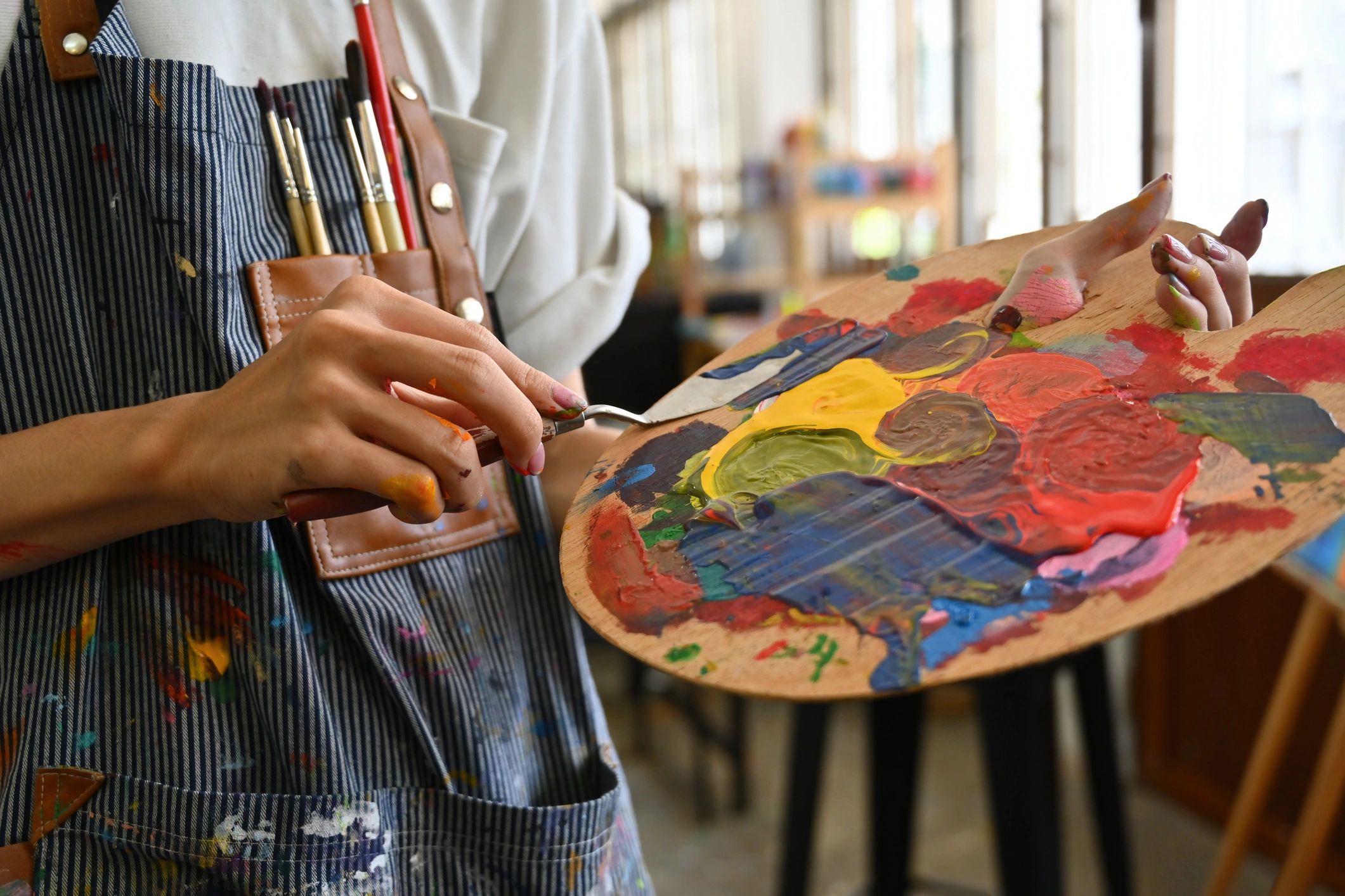 Artist mixing paint on a palette