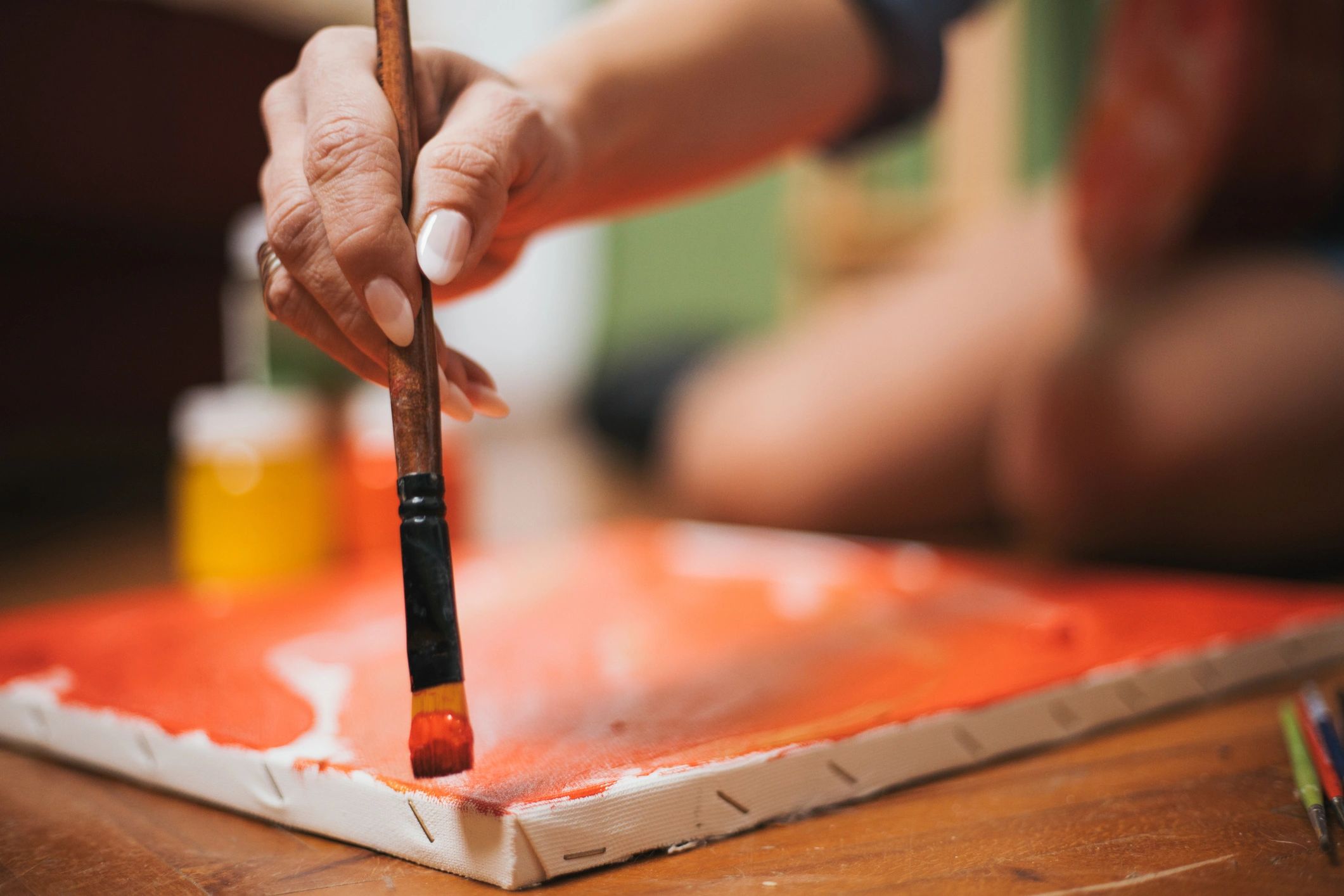 Artist painting on canvas in a relaxed setting